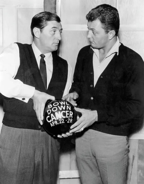 Framed Print : American actor Robert Mitchum and his son, Jim Mitchum, discussing Bowl Down Cancer Week, a week long bowling and cancer educational campaign, 1962
