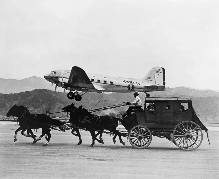 Framed Print : American Airlines DC-3 flying past horse drawn stagecoach. The photo was featured in an American Airlines magazine advertisement in 1949. (BSLOC_2015_14_193)