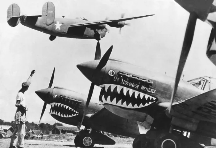 Framed Print : An American B-24 Liberator bomber takes off from an advanced U.S. base in China. On the ground are shark nosed P-40 fighters of the Flying Tigers, U.S Framed Print : An American B-24 Liberator bomber takes off from an advanced U.S. base in China. On the ground are shark nosed P-40 fighters of the Flying Tigers, U.S