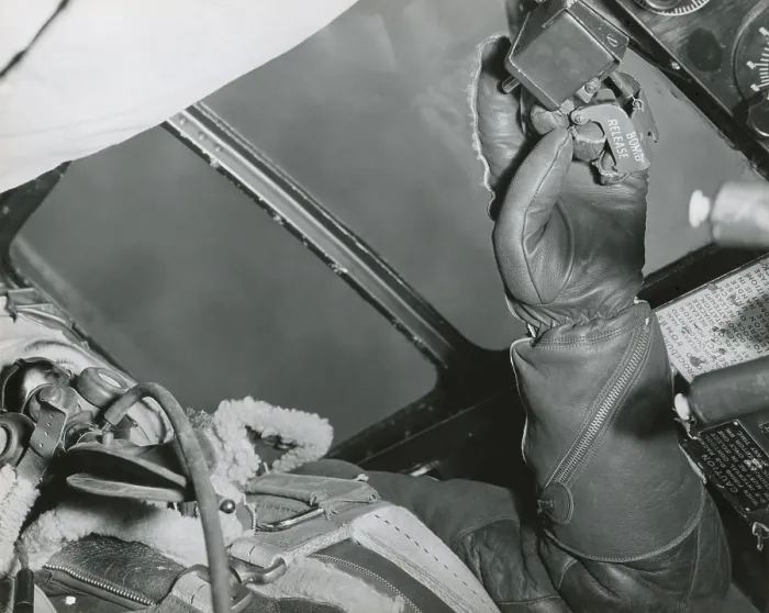 Framed Print : American Bombardier with his hand on the Bomb Release over Germany in 1943. His fleece lined leather gloves and jacket protect him for the cold at high altitudes