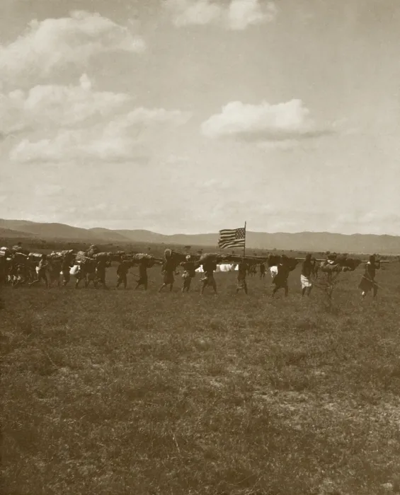 Framed Print : American flag flies on the Smithsonian-Roosevelt African Expedition, June 1909. African porters carry supplies and equipment near Nairobi with the safari camp in the background