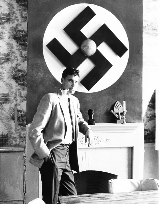 Framed Print : American Nazi George Lincoln Rockwell stands by a huge swastika on the wall over the fireplace Framed Print : American Nazi George Lincoln Rockwell stands by a huge swastika on the wall over the fireplace