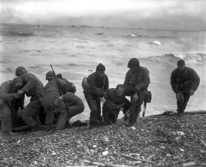Framed Print : American soldiers help others whose landing craft was sunk off Utah Beach on D-Day. The survivors reached the beach of Cherbourg by using a life raft. June 6, 1944, World War 2
