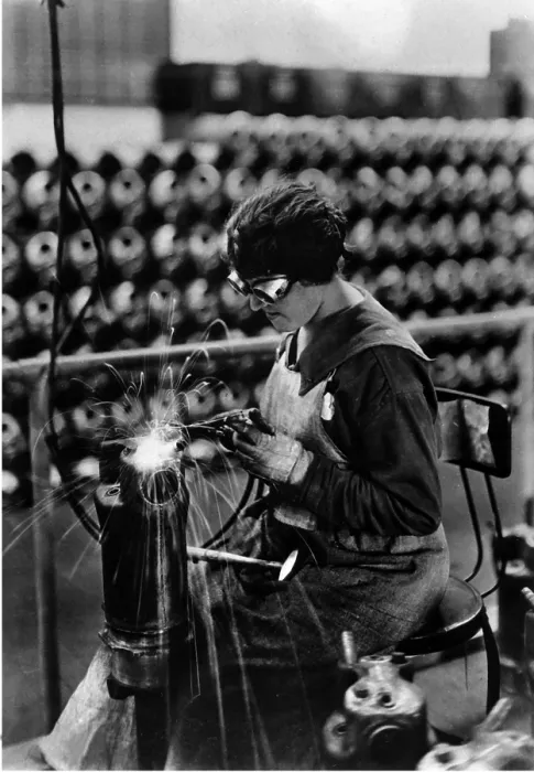 Framed Print : American woman performing acetylene welding on cylinder water jacket, a container filled with water that surrounds a machine, such a machine gun, to cool it. World War I. 1918