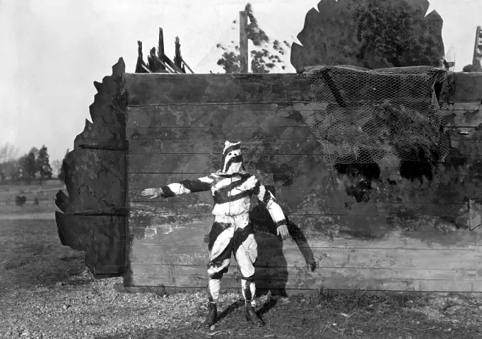Framed Print : American World War I soldier in black and white uniform to conceal him while climbing trees. He stands in front of a house camouflaged to represent a fence and trees. Nov Framed Print : American World War I soldier in black and white uniform to conceal him while climbing trees. He stands in front of a house camouflaged to represent a fence and trees. Nov