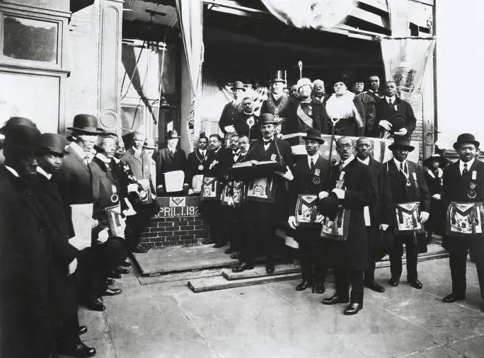 Framed Print : Arthur Alfonso Schomburg in a group of Masons and Odd Fellows, April 1, 1922. He is standing in front of brick wall, right of the inscription Framed Print : Arthur Alfonso Schomburg in a group of Masons and Odd Fellows, April 1, 1922. He is standing in front of brick wall, right of the inscription