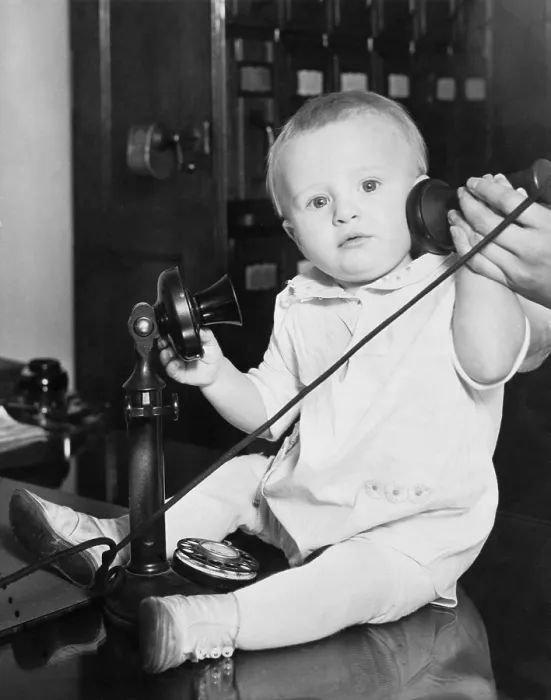 Framed Print : A baby found under a bed at the Stevens Hotel, Chicago, Illinois was photographed with a telephone to illustrate the many phone calls from people wanting to give him a home. 1930