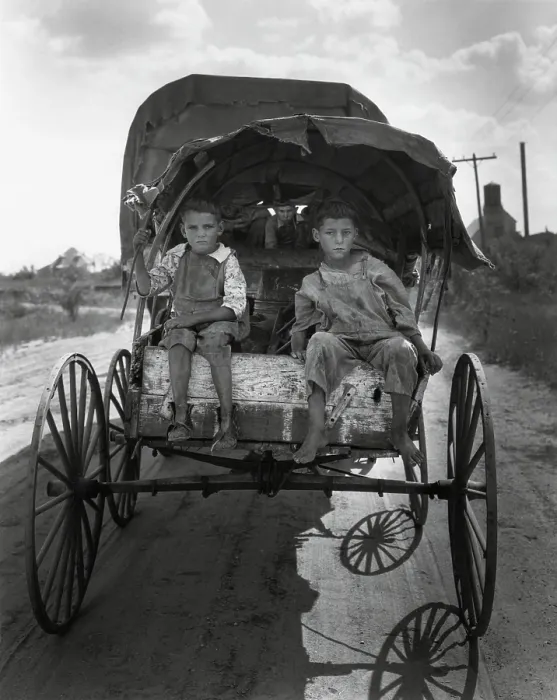 Framed Print : Barefoot children of migrant cotton pickers looking for work in Texas, Sept. 1931. Two boys sit on the back of a metal wheeled covered wagon pulled by another vehicle Framed Print : Barefoot children of migrant cotton pickers looking for work in Texas, Sept. 1931. Two boys sit on the back of a metal wheeled covered wagon pulled by another vehicle