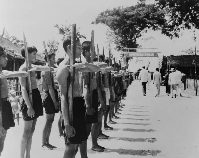 Framed Print : Barefoot villagers perform training drills using bamboo rifles at a French Legionnaire outpost. Batri, French Indochina, 1951. - (BSLOC_2014_15_187)