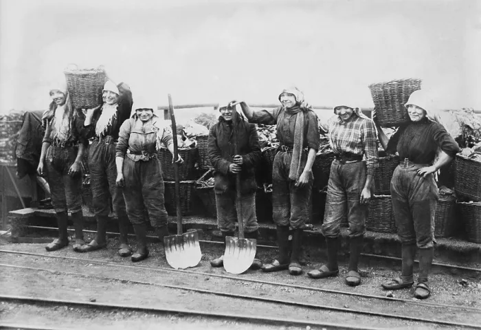Framed Print : Belgian women coal miners dressed in trousers. They wear workers clogs and headscarves, and tight belts that emphasize their waists. Between 1900-1920