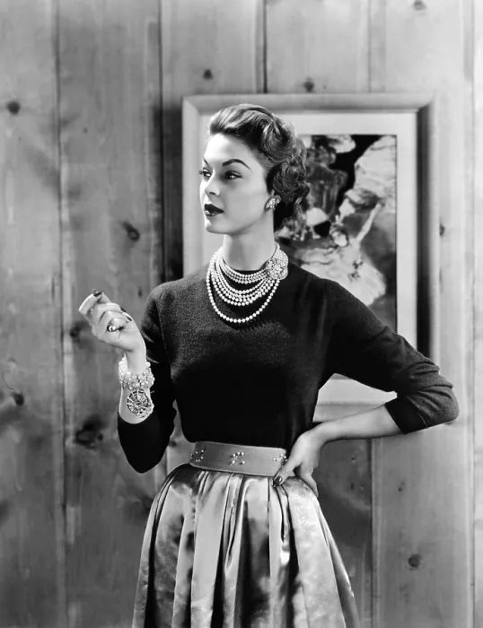 Framed Print : Black cashmere pullover is worn with a satin gathered full skirt and wide belt emphasizing the narrow waist Framed Print : Black cashmere pullover is worn with a satin gathered full skirt and wide belt emphasizing the narrow waist