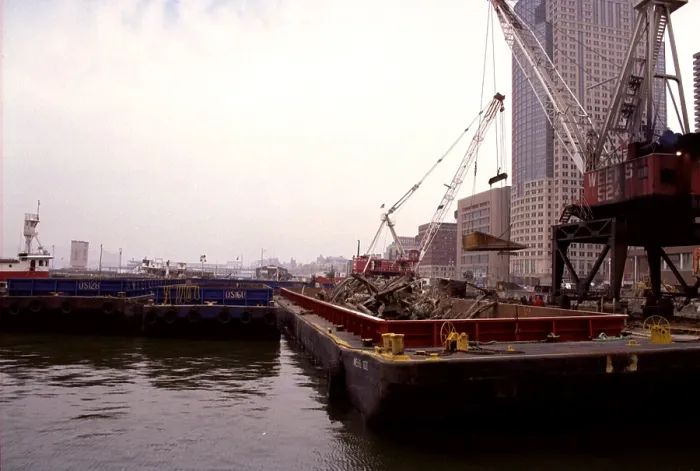 Framed Print : A few blocks from Ground Zero heavy cranes place World Trade Center wreckage into barges for transport to the Fresh Kill Landfill on Staten Island. March 15 2002