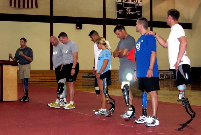 Framed Print : Brian Frasure paralympian speaking at a Military Amputees Training workshop while flanked by seven soldiers wearing advanced artificial legs. Walter Reed Army Medical Center
