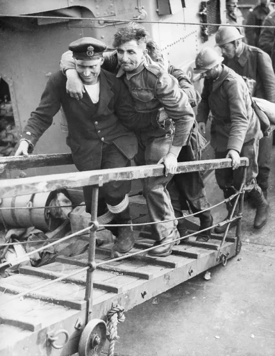 Framed Print : A British sailor assisting a wounded Tommy followed by French Troops. They are arriving safely in England from the beaches of Dunkirk. World War 2. May 26-June 4, 1940