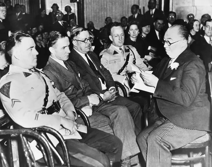 Framed Print : Bruno Hauptmann (2nd from felt) sitting between State Troopers and a Sheriff at his trial. At right holding paper is Hauptmann's defense counsel, Edward J. Reilly