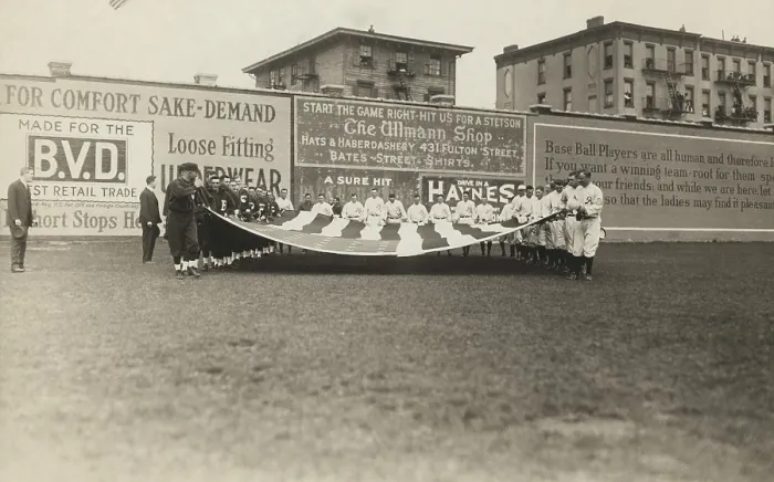 Framed Print : Buffalo Bisons and Brooklyn Tip Tops baseball players holding a large American flag, 1914. The first singing of THE STAR SPANGELED BANNER at a baseball game occurred in 1887