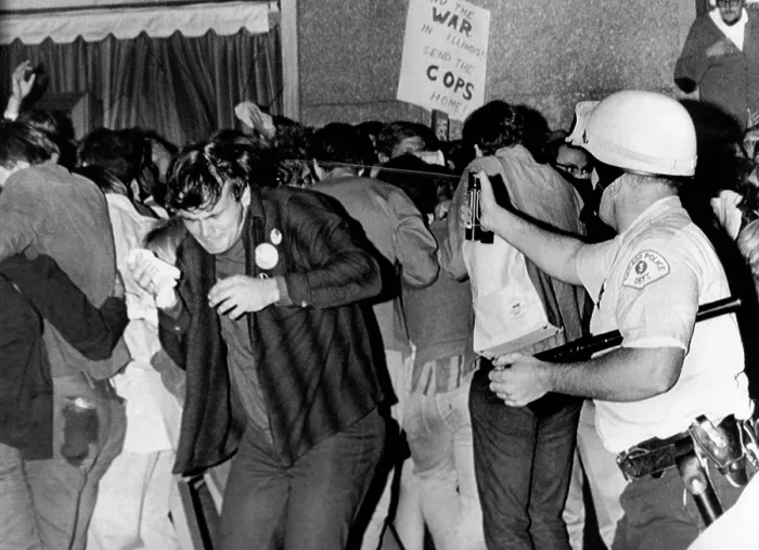Framed Print : Chicago Police officer (right) uses pressure can to squirts mace at anti-Vietnam War demonstrators