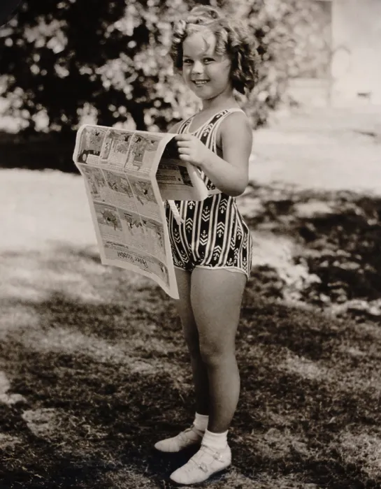 Framed Print : Child actress, Shirley Temple, reads the funny papers at the Desert Inn, Palm Springs, March 6, 1936 (BSLOC_2018_3_12)