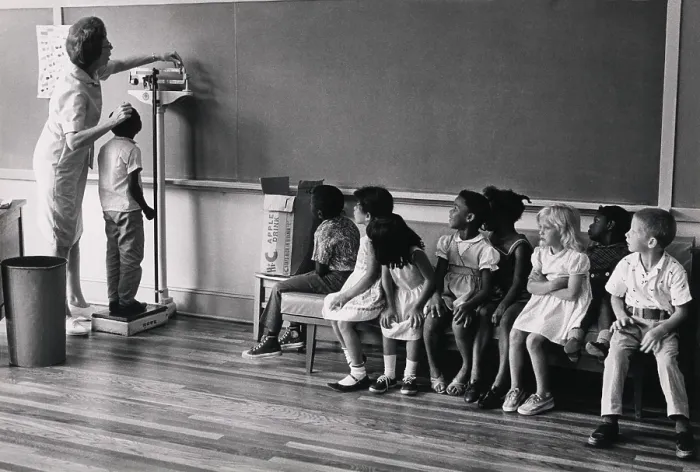 Framed Print : Children of migrant workers being measured for height, at school for children in New Jersey, 1956. Photograph by Louise Rosskam