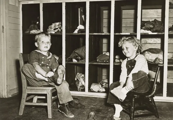 Framed Print : Children take off their shoes before a nap in a public nursery during World War 2 Framed Print : Children take off their shoes before a nap in a public nursery during World War 2
