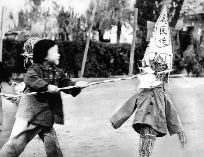 Framed Print : A Chinese kindergarten girl thrusts a spear into a straw effigy labeled with a sign, which roughly translated reads US bad guys