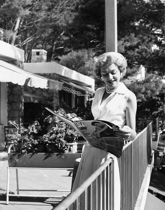 Framed Print : Christine Jorgensen, leafing through a film magazine on Capri, Italy, Sept. 22, 1954 Framed Print : Christine Jorgensen, leafing through a film magazine on Capri, Italy, Sept. 22, 1954