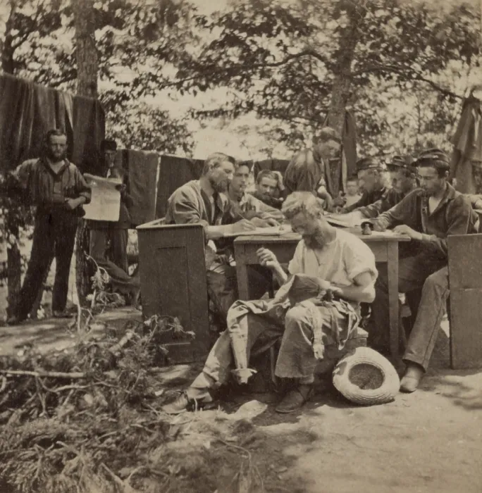 Framed Print : US Civil War, June 1861. Boston Light Artillery soldiers in camp at Relay House, Maryland, sit at a long table, writing letters. One soldier, in the foreground is sewing