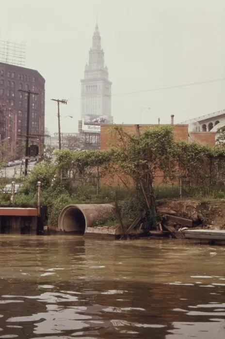 Framed Print : A Cleveland city pump station discharges sewage into the Cuyahoga River. In the background is the Terminal Tower a landmark skyscraper in downtown Cleveland. Ca. 1973-75