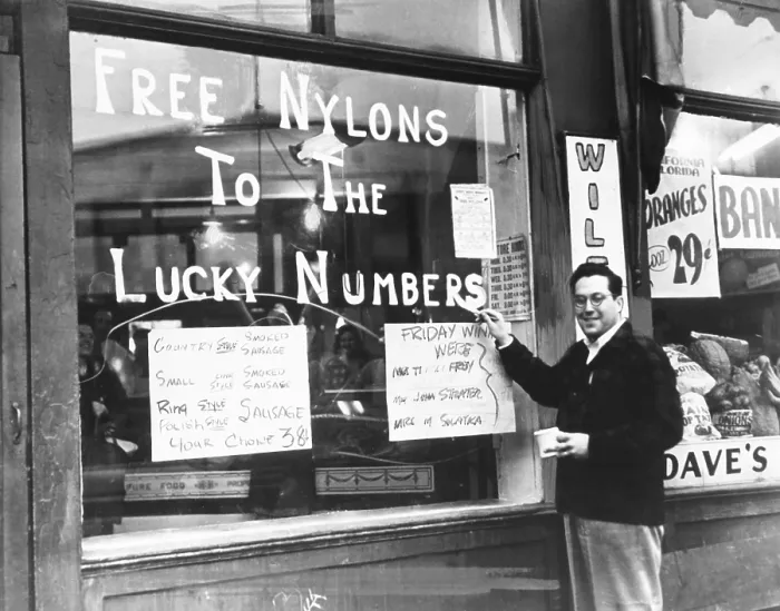 Framed Print : Cleveland grocer Max Astor promoting his grocery store with Free Nylons to the Lucky Numbers'. Nov. 5, 1946. He posts his meat specials, all of which are sausage