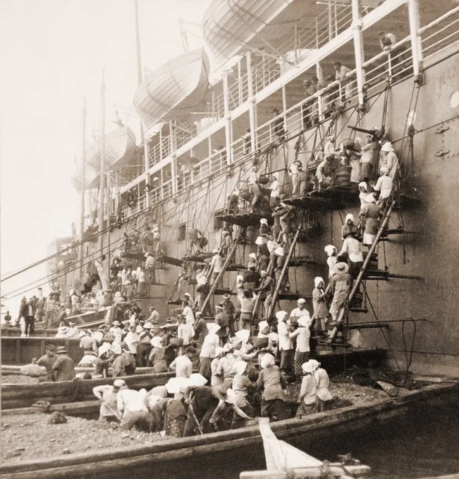 Framed Print : Coaling station in Nagasaki, Japan. Young men and women on barges and scaffolding form a bucket brigade, passing coal up the side of the mail ship during refueling