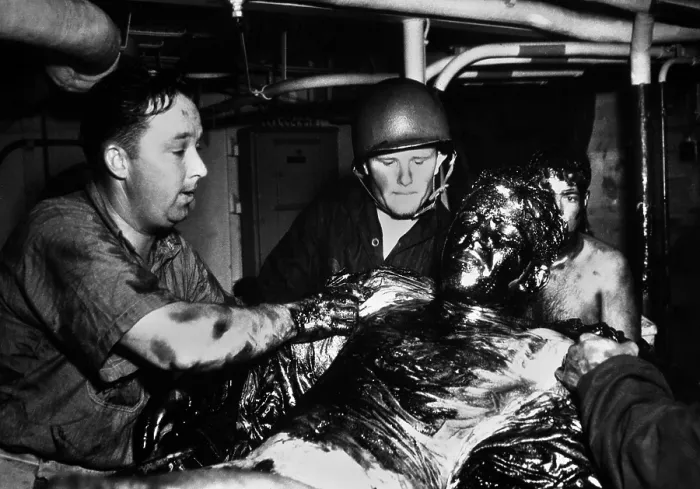 Framed Print : Coast Guardsmen scrape a thick coating of oil from the body of U.S. Navy seaman Framed Print : Coast Guardsmen scrape a thick coating of oil from the body of U.S. Navy seaman