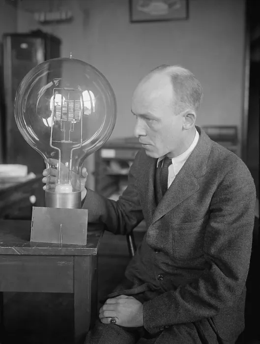 Framed Print : C.W. Mitman, Head Curator, Department of Engineering and Industries of the Smithsonian Institute, holds a giant light bulb. For contrast a midget bulb is placed beside it