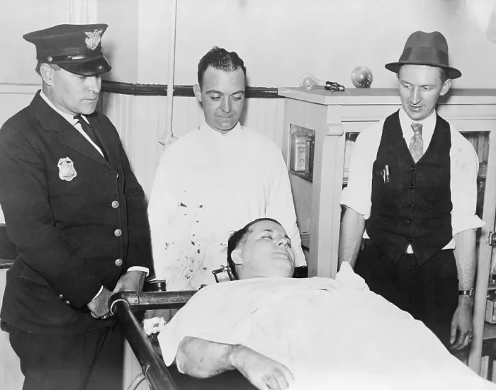 Framed Print : Dead body of Charles Pretty Boy Floyd (1904-1934) on a gurney with police officers Robert Pyle and George Curran, and undertaker Frank Dawson standing nearby