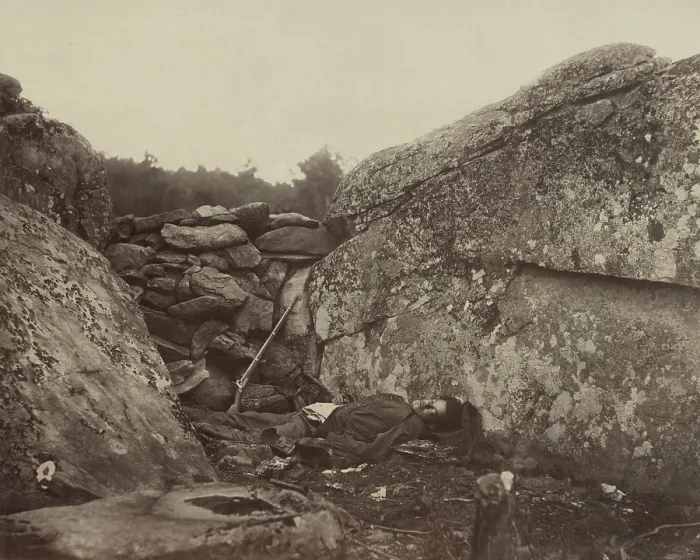 Framed Print : A dead Confederate soldier lies in the Devil's Den, against a wall of stones, with his rifle, on the Gettysburg battlefield, c. July 4-6, 1863