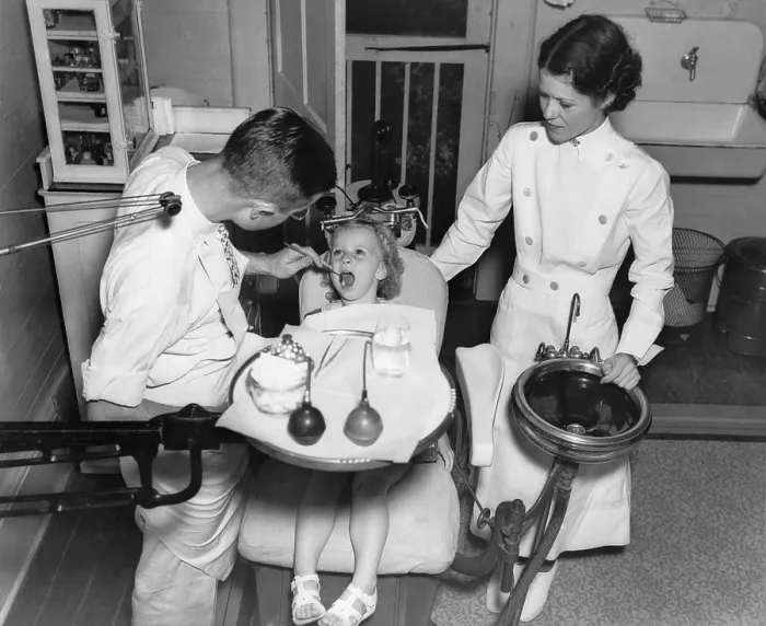 Framed Print : A dentist examining a young girl's teeth in 1942