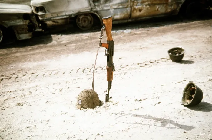 Framed Print : Discarded Iraqi helmets scattered around a Kalashnikov assault rifle near vehicles destroyed by Coalition forces during Operation Desert Storm. Mar. 1 1991 (BSLOC_2011_12_8)