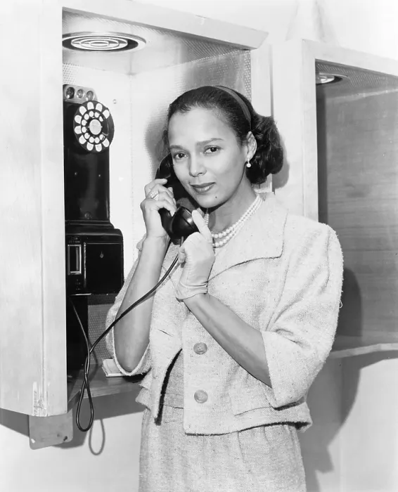 Framed Print : Dorothy Dandridge (1922-1965), half-length portrait, standing, facing left, holding telephone receiver at New York's airport in 1959, the year she starred in PORGY AND BESS