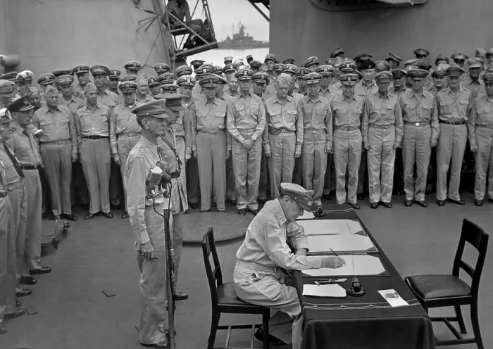 Framed Print : Douglas MacArthur signs documents during Japanese surrender ceremonies on the USS MISSOURI in Tokyo Bay. Standing behind MacArthur are Gen. Jonathan Wainwright and British Gen