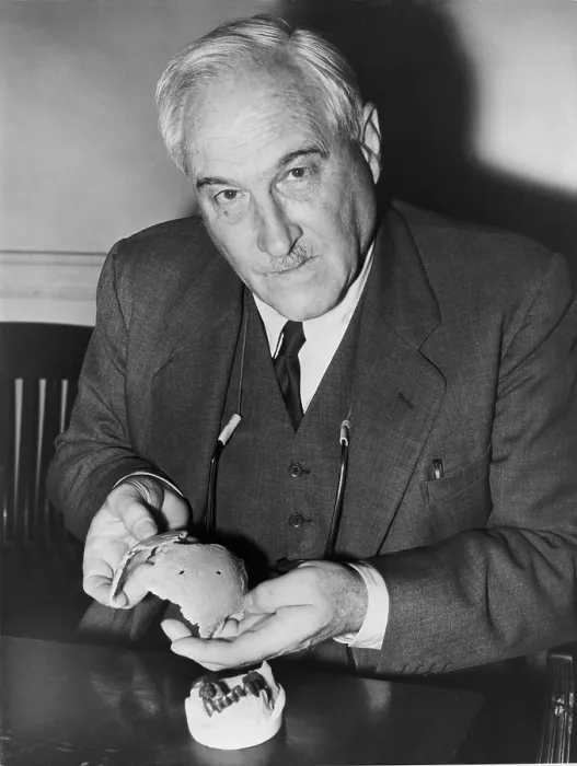 Framed Print : Dr. Louis Leakey (1903-1972), Kenyan archaeologist holding pieces of 600, 000 year-old human skull