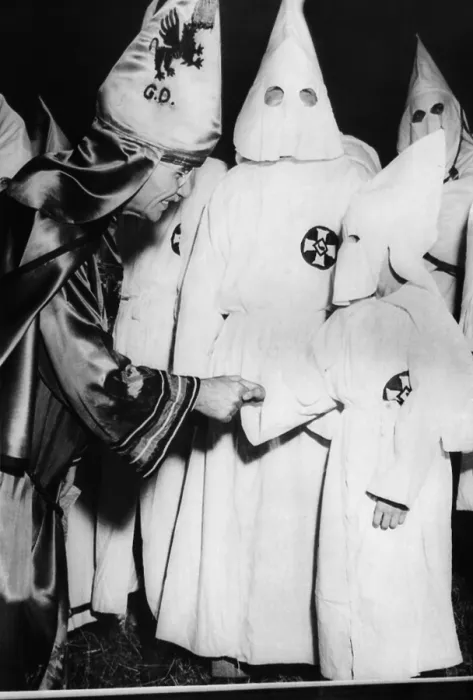 Framed Print : Dr. Samuel Green (left), Grand Dragon of the Ku Klux Klan, greets a small boy dressed in Klansman's robes