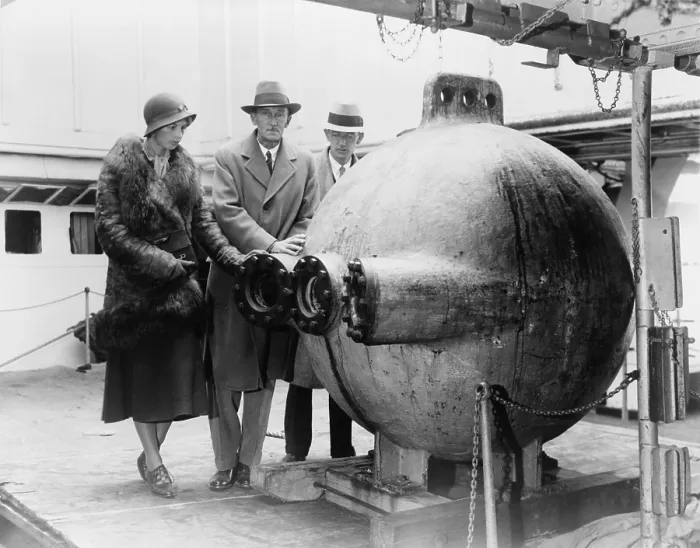 Framed Print : Dr. William Beebe (center) standing with two assistants, next to the bathysphere, a deep-sea submersible lowered into the ocean on a cable
