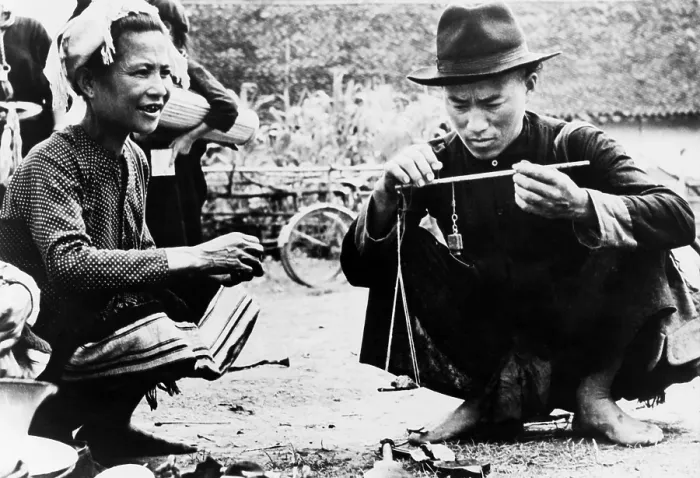 Framed Print : Drug seller openly weighing opium for a customer in an outdoor market in Laos. 1954 Framed Print : Drug seller openly weighing opium for a customer in an outdoor market in Laos. 1954