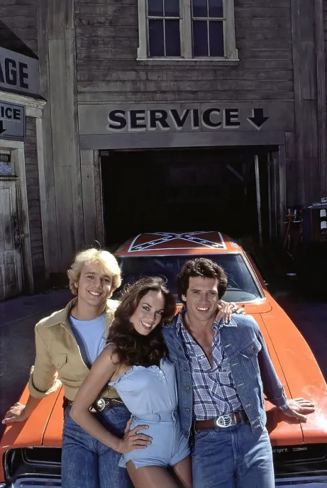 Framed Print : THE DUKES OF HAZZARD, from left: John Schneider, Catherine Bach, Tom Wopat, 1979-1985 Framed Print : THE DUKES OF HAZZARD, from left: John Schneider, Catherine Bach, Tom Wopat, 1979-1985