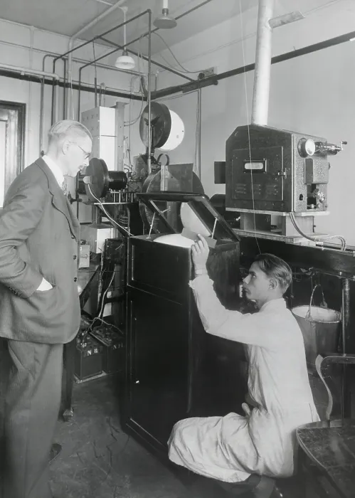Framed Print : Early television with a viewing mirror that reflects the image of an encased picture tube. In the background is the camera and transmission devices. Ca. 1930