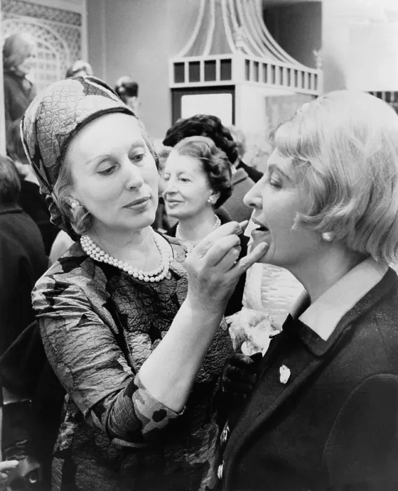 Framed Print : Estee Lauder 1906-2004 cosmetics business leader dressed in an Yves Saint Laurent dress applies lipstick to a customer in New York City. 1966. (BSLOC_2010_18_158) Framed Print : Estee Lauder 1906-2004 cosmetics business leader dressed in an Yves Saint Laurent dress applies lipstick to a customer in New York City. 1966. (BSLOC_2010_18_158)