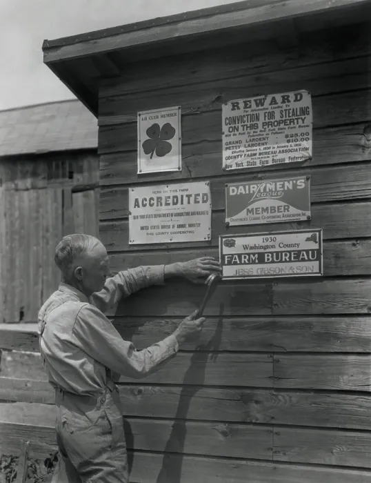 Framed Print : Farmer attaches another membership sign to his barn, Washington County, New York, 1930. Agricultural organizations encouraged more effective farming and lessened rural isolation