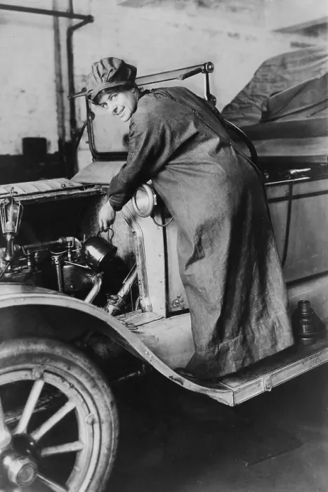 Framed Print : Female auto saleswoman, Rosalie Jones, attends to auto mechanics in a duster and hat in 1925