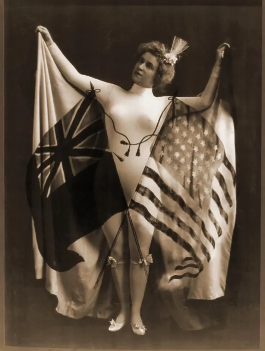 Framed Print : Female vaudeville performer in white body suit, wearing a cape of U.S. and British flags