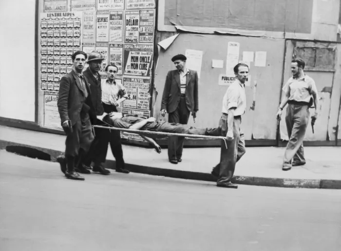 Framed Print : F.F.I. (French Forces of the Interior) partisan carried on stretcher, possibly in Paris. Other men carrying pistols walk alongside. Ca. July-Aug. 1944. World War 2