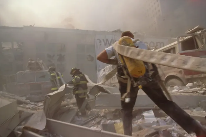 Framed Print : Fire fighters hauling a hose through rubble on September 11th, following terrorist attack on World Trade Center